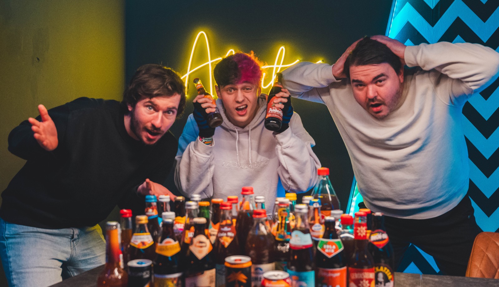 Manu, Fabi und Schorsch hinter einem Tisch voller Cola-Mix-Flaschen